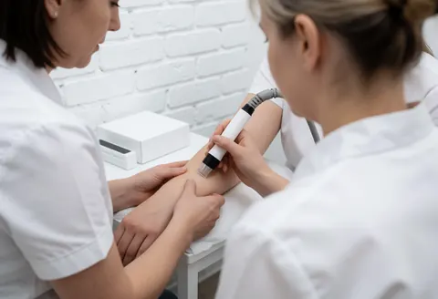 Séance de thérapie laser réalisée en clinique par une esthéticienne professionnelle.