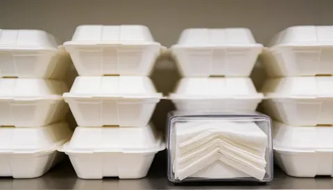 Arrière-plan flou de boîtes de repas et distributeur de serviettes, adapté pour textes et publicités en restauration.