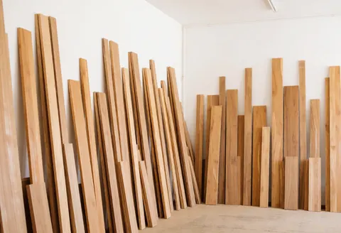 Vue intérieure d'un atelier de menuiserie propre et organisé, avec des planches de bois empilées sur des étagères.
