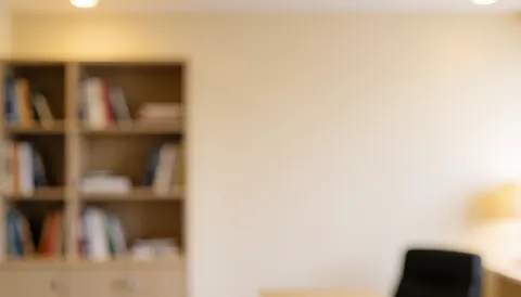 Intérieur calme d'une agence de voyages avec étagères remplies de livres et murs blancs, offrant un arrière-plan professionnel idéal pour ajouter du texte ou des éléments graphiques.