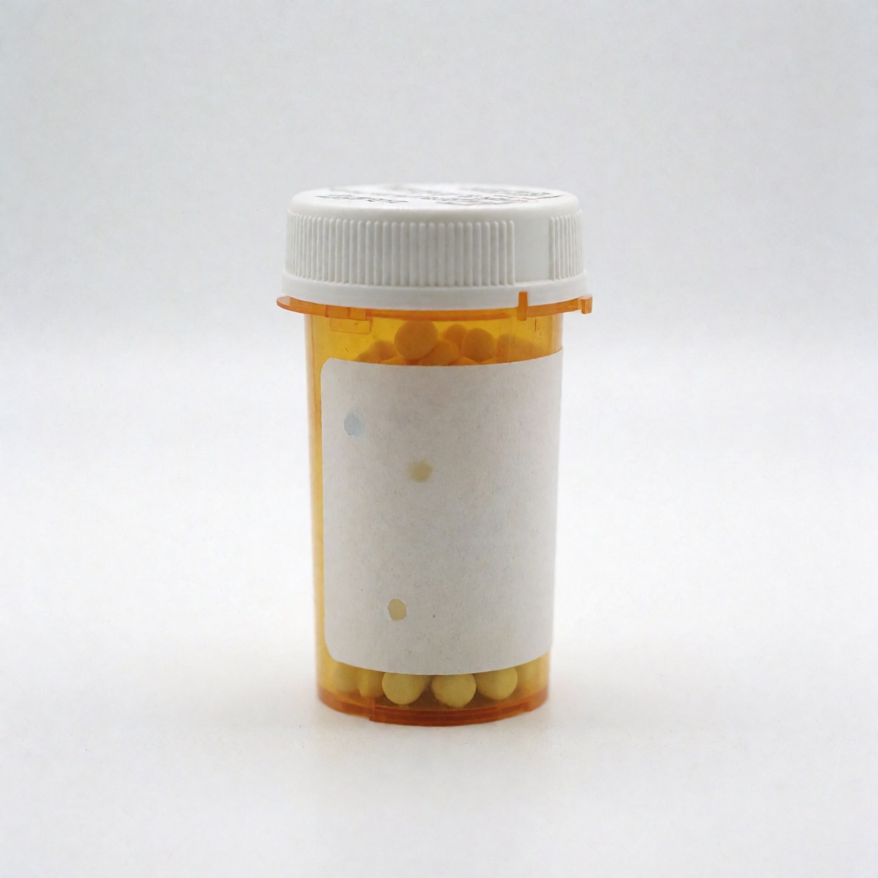 Un flacon de médicaments posé sur un fond blanc uni, représentant un produit pharmaceutique.