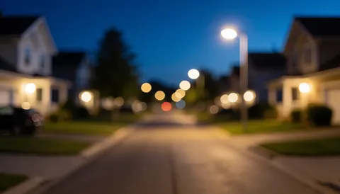 Rue calme la nuit avec des lumières floues et un ciel bleu foncé servant de fond pour du texte.