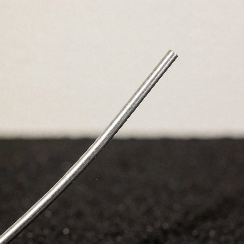 Gros plan sur une soudure métallique brillante avec du fil de soudage, montrant la texture et le fini sur un fond sombre.