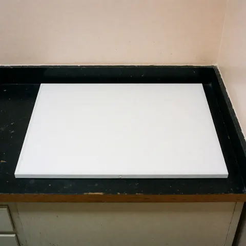 Vue de dessus d'un filtre à air rectangulaire blanc propre posé sur une surface plane, utilisé pour le remplacement et l'installation par un technicien.