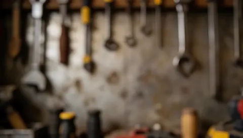 Fond de travail montrant des outils accrochés à une paroi industrielle, créant une texture brute et professionnelle adaptée au texte.