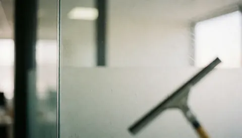 Fond neutre représentant un environnement de bureau professionnel avec des surfaces vitrées propres et lumineuses, idéal pour intégrer du texte ou des éléments graphiques dans une présentation corporative.