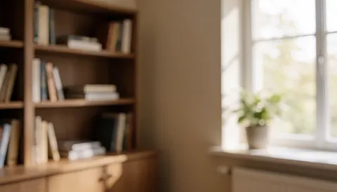 Espace de travail calme comprenant une étagère chargée de livres, une fenêtre laissant entrer la lumière naturelle et une plante verte, servant de fond idéal pour des contenus liés à la finance.