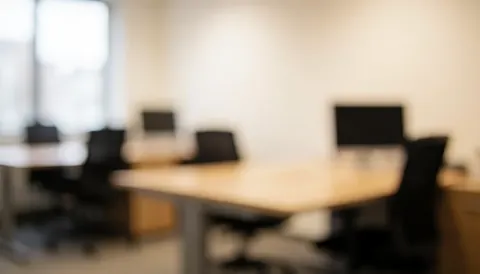 Arrière-plan flou d'un bureau moderne avec tables et chaises, lumière douce et ambiance professionnelle idéale pour textes et présentations.