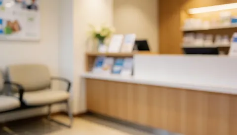 Réception d'optique avec chaise d'attente et comptoir avec brochures, fond doux et chaleureux, idéal pour textes commerciaux.