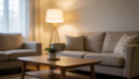 Arrière-plan d'un salon confortable avec canapé, table basse et lampe, idéal pour textes immobiliers liés à la vente ou la location de maisons.
