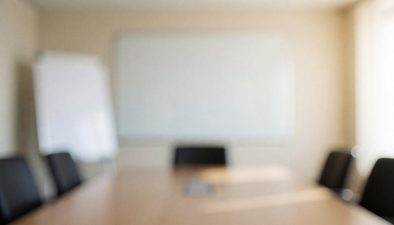 Vue d'une salle de réunion professionnelle vide comprenant une grande table de conférence et un tableau blanc sur le mur pour des présentations.