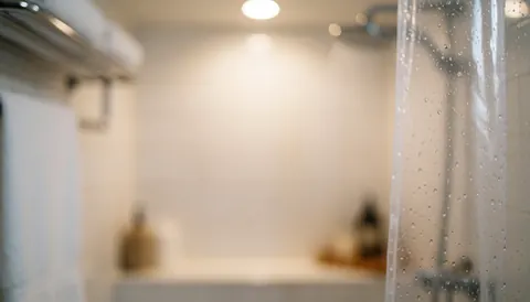 Arrière-plan doux et chaleureux d'une salle de bain avec une serviette suspendue, évoquant le bien-être et la relaxation.