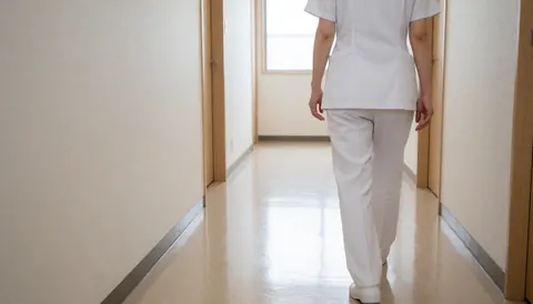 Un thérapeute en uniforme blanc marche dans un couloir lumineux et propre d'une clinique médicale, évoquant le soin et le bien-être.