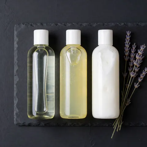 Vue de dessus d'une collection variée de produits de massage incluant huiles, gels, crèmes, pierres chaudes et lavande pour le bien-être et la relaxation.