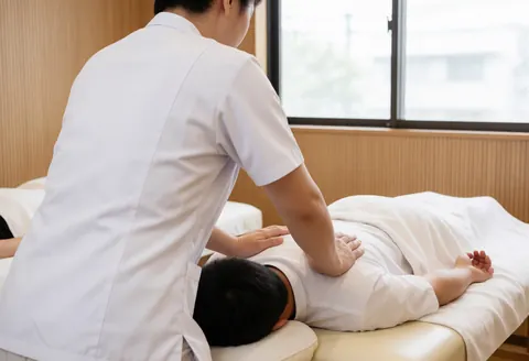 Un chiropraticien effectue un ajustement spinal sur un patient allongé sur une table de massage dans un cabinet professionnel.