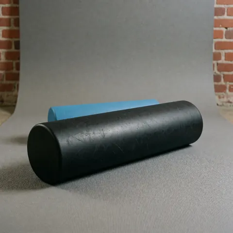 Gros plan d'une texture de mousse poreuse posée sur une surface en bois clair, évoquant le confort et la relaxation.