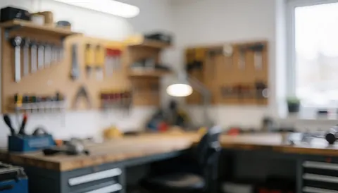 Arrière-plan net d'un atelier professionnel avec des outils disposés sur une table, créant un effet de flou artistique pour mettre en valeur le texte.