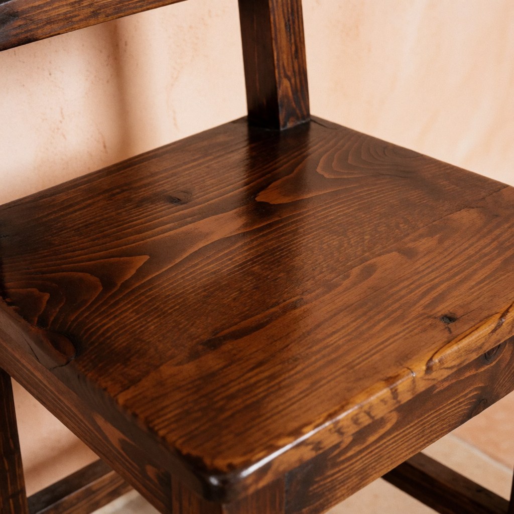 Vue rapprochée d'une chaise ancienne en bois de cèdre avec finition brillante et détails du grain.
