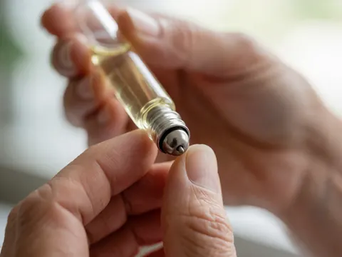 Vue rapprochée d'un flacon applicateur à rouleau en métal contenant de l'huile essentielle pour l'aromathérapie et les soins de la peau.