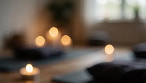 Un fond chaleureux avec des bougies allumées posées sur des tapis de yoga, créant une ambiance calme et relaxante idéale pour la méditation prénatale.