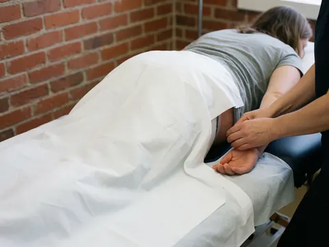 Vue rapprochée d'une table de massage professionnelle équipée de supports pour femmes enceintes, destinée aux séances de soins maternels.