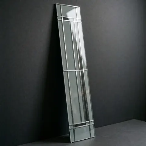 Panneau mural décoratif aux lignes géométriques noires, en verre et métal, éclairé en studio pour un usage produit.