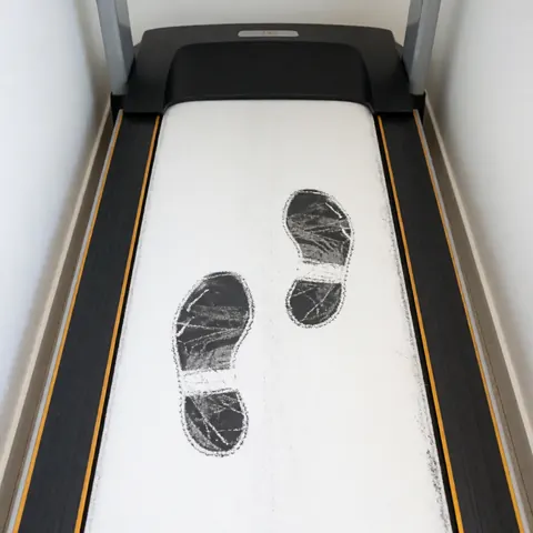 Analyse de la foulée réalisée sur un tapis roulant avec des empreintes de craie au sol pour évaluer la marche et la rééducation.