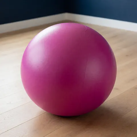Une boule de naissance de couleur magenta utilisée pour le massage maternel et la préparation à l'accouchement.