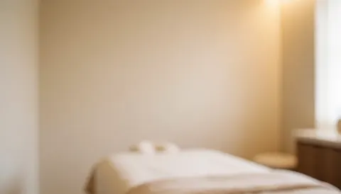 Arrière-plan flou aux tons beige et blanc évoquant la sérénité, idéal comme support textuel pour des services de bien-être et de massage en entreprise.