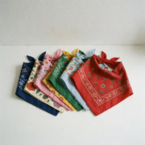 Vue de dessus d'une collection variée de bandanas colorés à motifs floraux et géométriques sur fond blanc, idéale pour la personnalisation de vêtements pour chiens et chats.