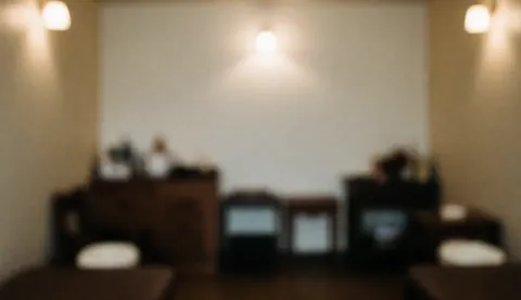 Fond d'étude de massage thaïlandais avec lumières chaudes, meubles en bois et tons terreux, idéal pour texte et design commercial.