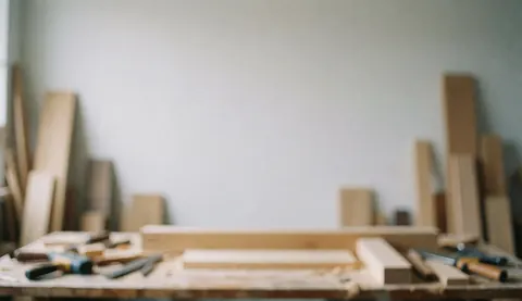Arrière-plan flou d'un atelier de menuiserie avec des planches de bois et des outils, idéal pour du texte ou des designs de meubles personnalisés.