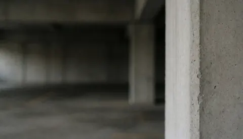 Fond professionnel de garage avec colonnes en béton, idéal pour textes, services de photographie et design graphique.