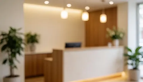 Intérieur d'une clinique montrant un espace de réception, des plantes vertes et un éclairage chaleureux, servant de fond pour du texte sur les services de santé holistique et le bien-être.
