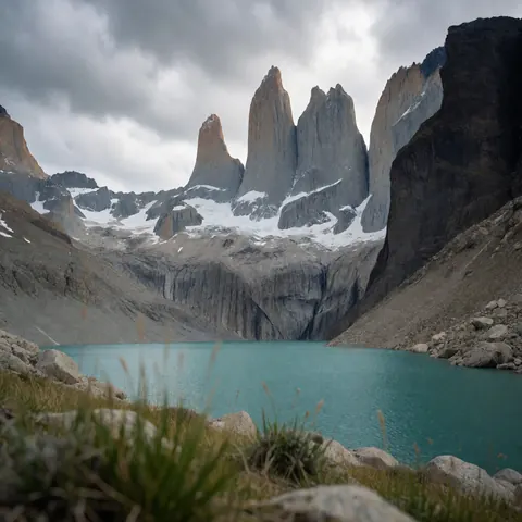 Vue panoramique réaliste des sommets de granit, d'un lac aux eaux turquoises et de nuages dramatiques dans un cadre naturel extérieur.