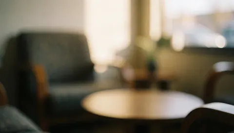 Arrière-plan flou d'une salle d'attente avec des chaises et une table, éclairage chaleureux et ambiance accueillante, idéal pour du texte sur les services de réparation.