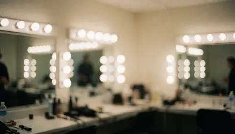 Arrière-plan flou d'une loge d'événement avec des miroirs, des lumières circulaires et des tables de maquillage. Idéal pour ajouter du texte sur la photographie d'événements.