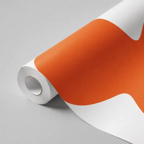 Rouleau de vinyle décoratif orange vif partiellement déroulé sur un fond gris neutre, idéal pour les murs et espaces modernes.