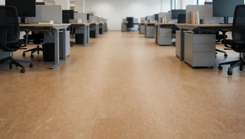 Vue d'un bureau professionnel au sol recouvert de liège beige, équipé de tables et de chaises ergonomiques, créant une ambiance calme et acoustique adaptée aux entreprises.