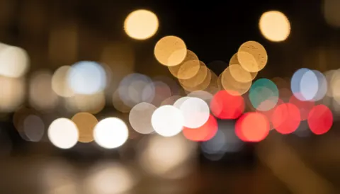 Fond de ville avec des lumières de voitures floues en tons chauds, idéal pour du texte ou du design graphique.