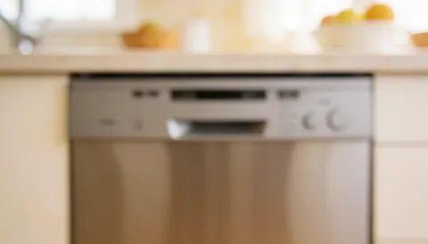 Arrière-plan de cuisine avec lave-vaisselle intégré, surfaces propres et éclairage chaleureux, idéal pour des textes commerciaux.