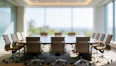 Salle de conférence moderne avec tables et chaises vides, éclairée par la lumière naturelle, idéale pour présentations ou textes corporatifs.