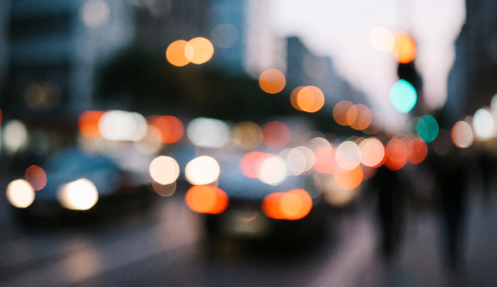 Fond abstrait de rue avec des lumières de voitures et de lampadaires floues en tons chauds et froids, idéal pour superposer du texte commercial.