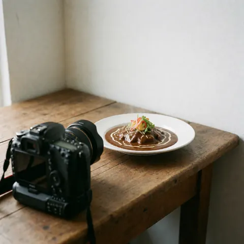 Appareil photo reflex professionnel en gros plan, focalisé sur un plat de mole mexicain garni, posé sur une table en bois rustique avec des murs blancs en arrière-plan.