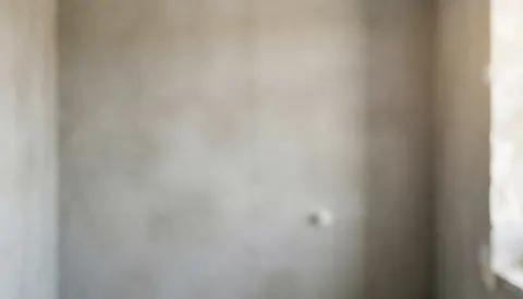 Fond de murs en ciment gris dans une salle de bain en rénovation, idéal pour du texte, éclairage doux et diffus, sans personnes ni objets, parfait pour les services d'installation de salles de bain.