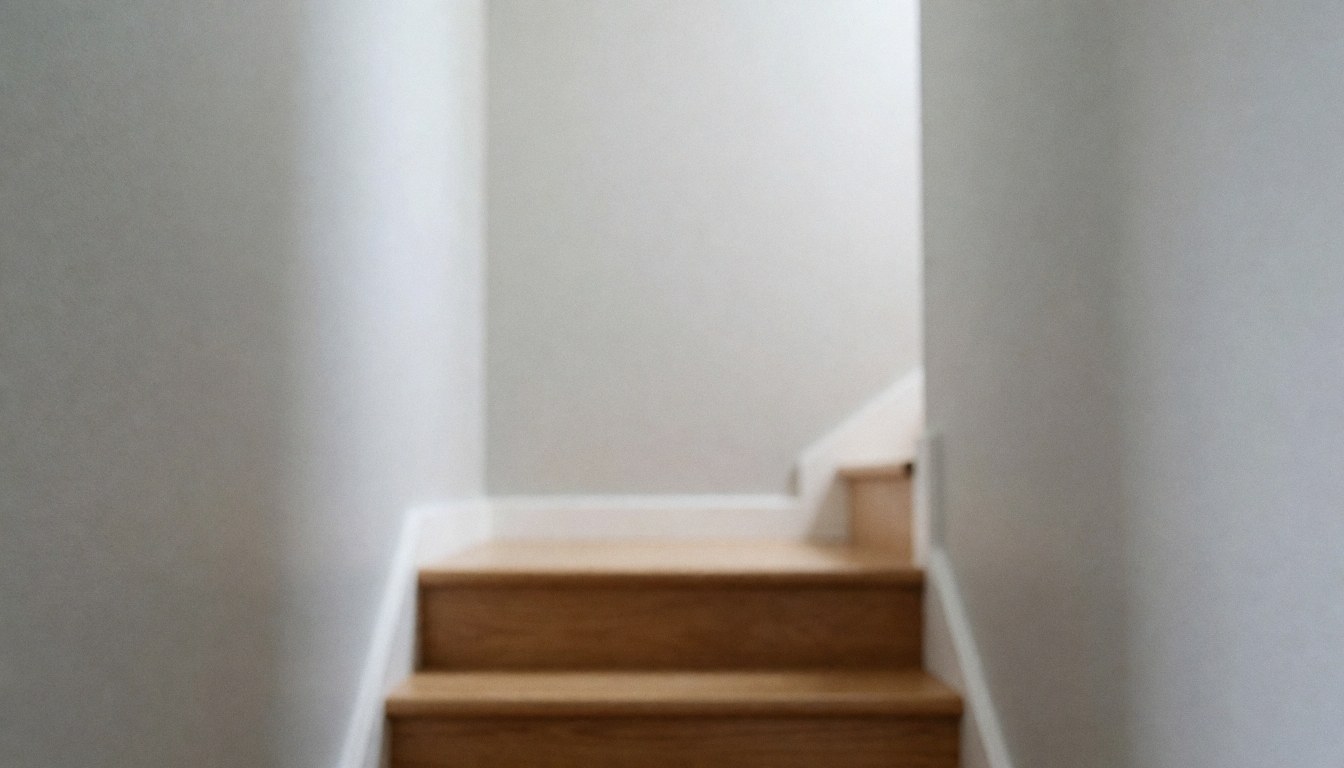 Escaliers en bois avec murs gris, fond doux pour texte, idéal pour publicités de peinture de maisons.