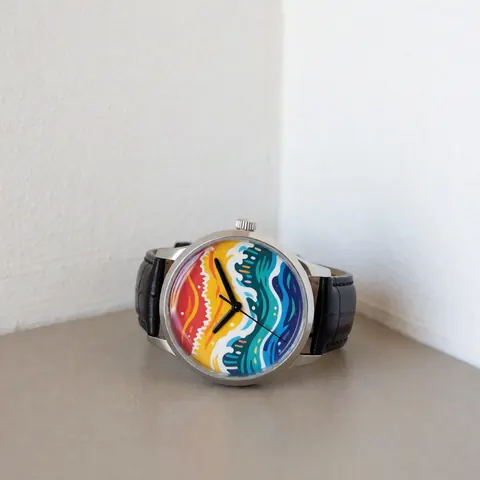 Montre-bracelet avec un cadran aux motifs d'ondes tropicales colorées et une lanière noire, posée sur une surface neutre sous un éclairage naturel, idéale pour un catalogue de produits.