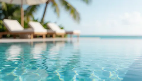 Fond de piscine à débordement avec chaises de plage et palmiers flous, idéal pour textes de vacances de luxe