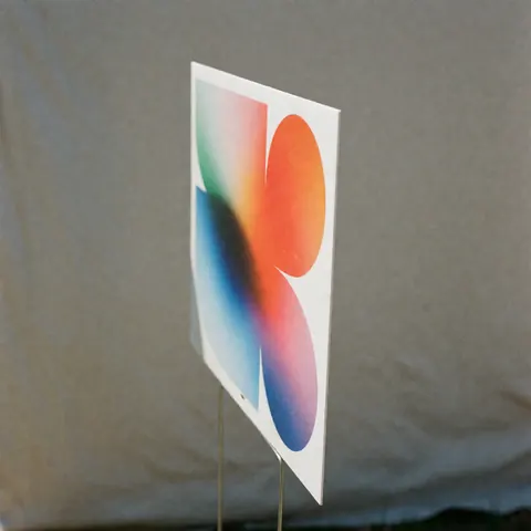 Panneau publicitaire en matériau ondulé gris montrant un motif textile moderne avec des dégradés vibrants et une forme géométrique sur fond neutre.