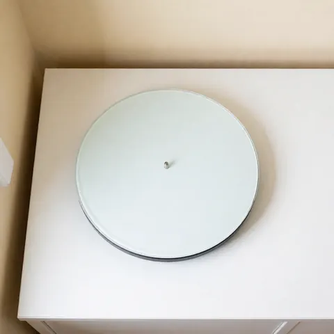 Assiette blanche pour micro-ondes neuve et propre posée sur une surface blanche avec un éclairage uniforme et des murs beige, idéale pour un catalogue de pièces détachées.